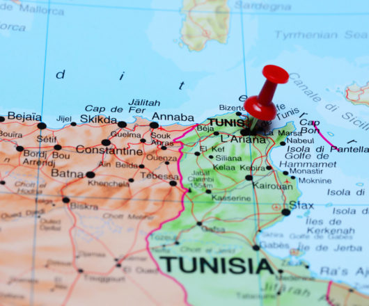 Photo of pinned Tunis on a map of Africa. May be used as illustration for traveling theme.